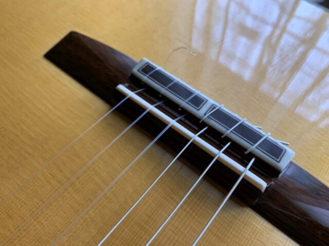 Stringing the bridge of a classical guitar
